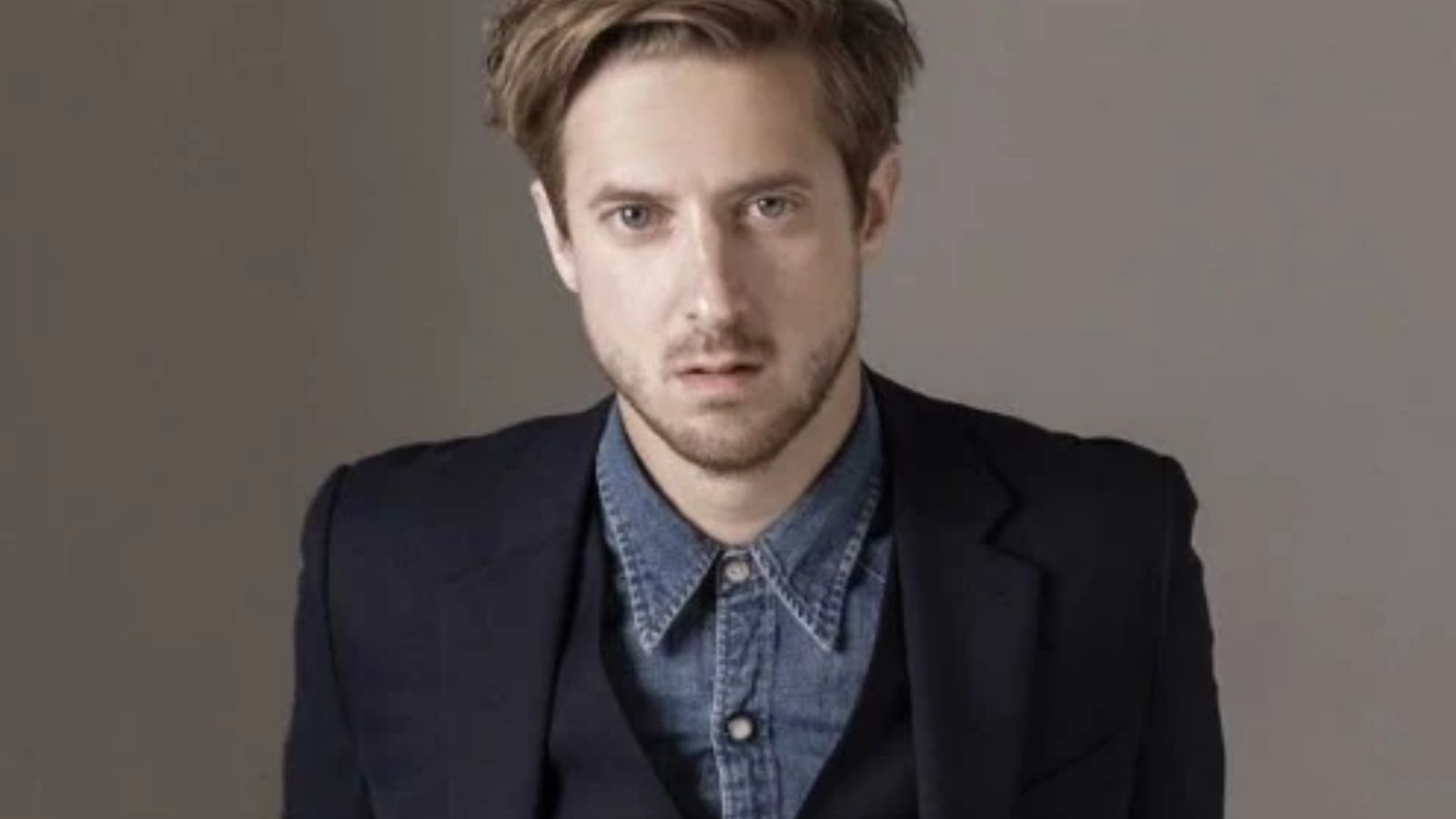 a geeky white man with dark reddish hair and a beard