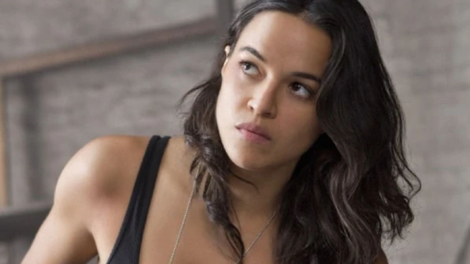 a latinx woman with long dark brown hair wearing a tank top 