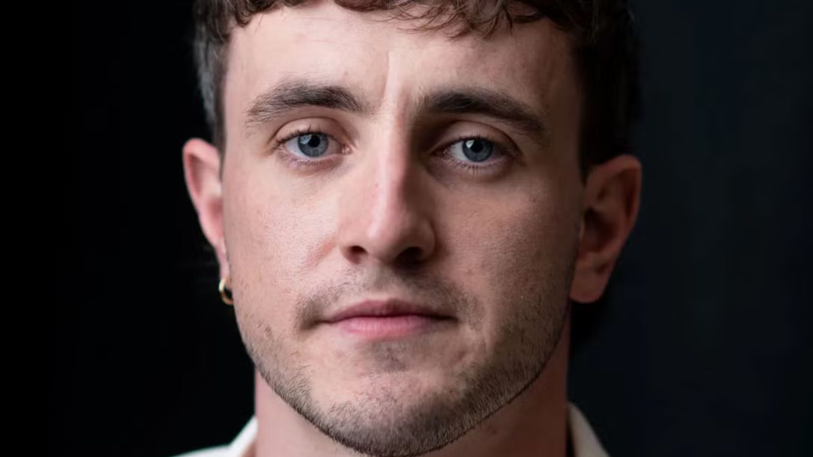 a white man with curly short dark hair and beard.