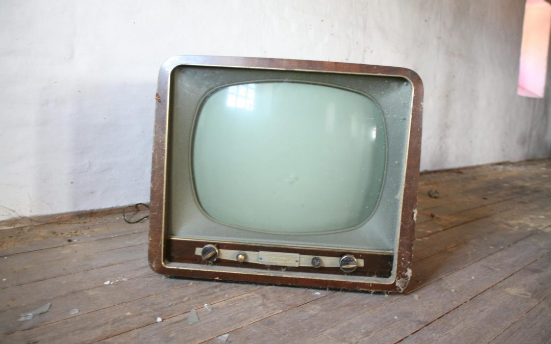 And old vintage tv sitting on the floor.