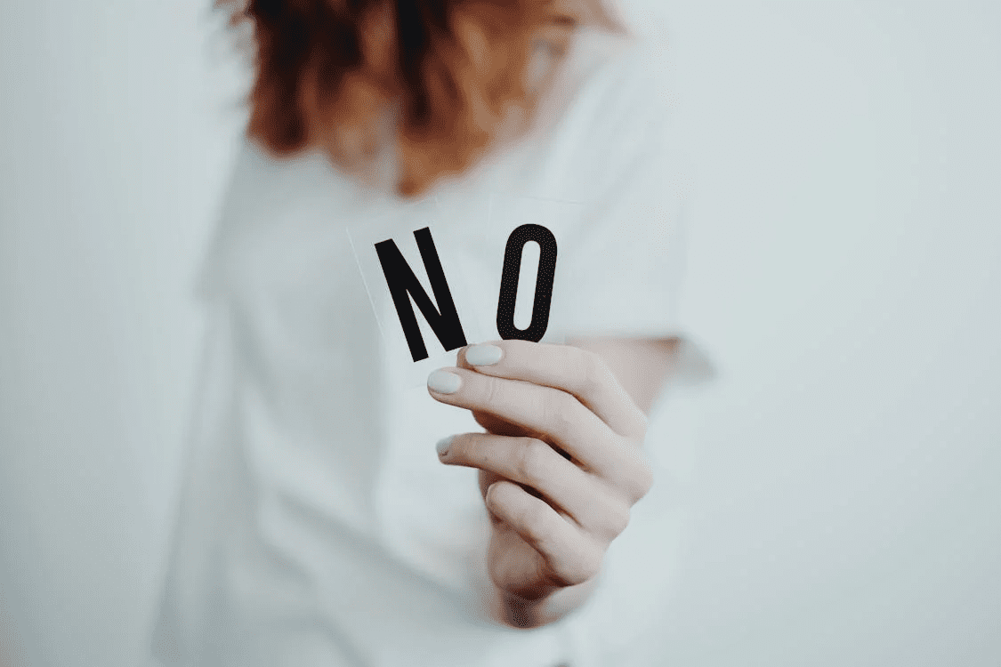 Chapter 2 Behind Closed Doors A photo of a woman holding two letter cards that spell no.