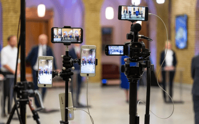 an image that shows phones setting up as cameras on tripods as they film a press conference.