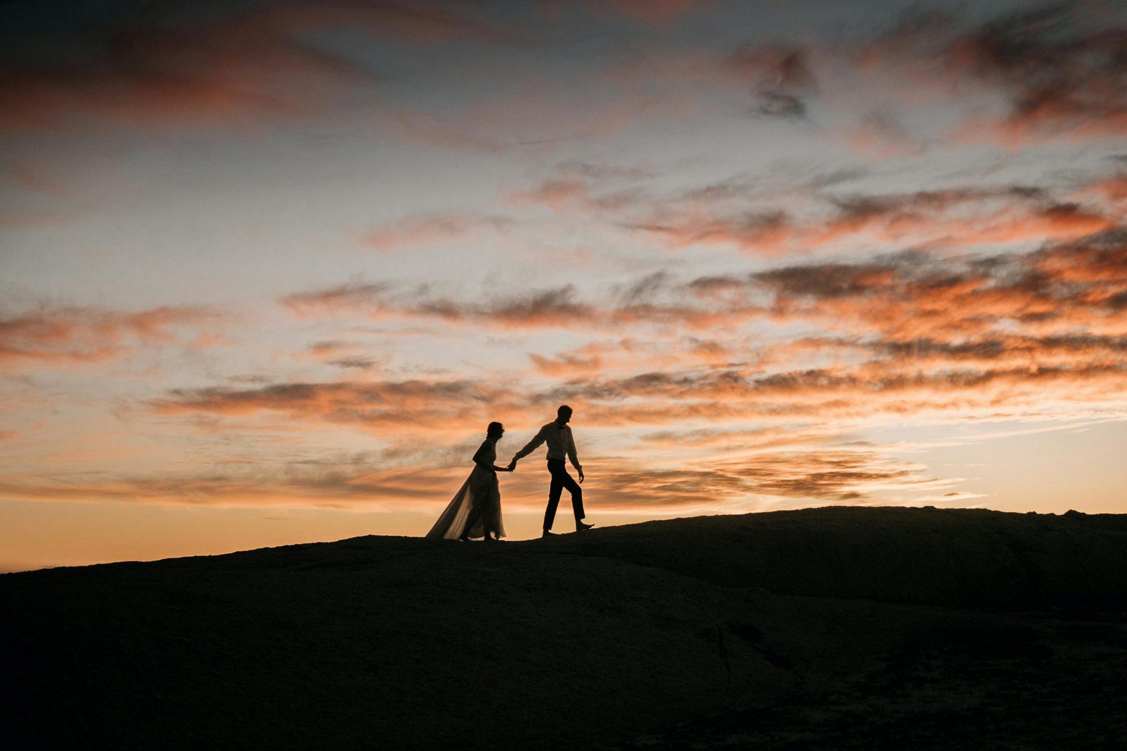 29. Put Up or Shut Up! An image of a silhouette of a couple standing on top a sunset lit hill.