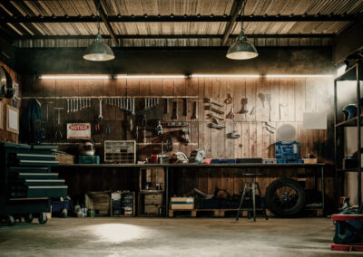 an image of the interior of aa motorcycle repair shop Workshop scene. Old tools hanging on wall in workshop, Tool shel