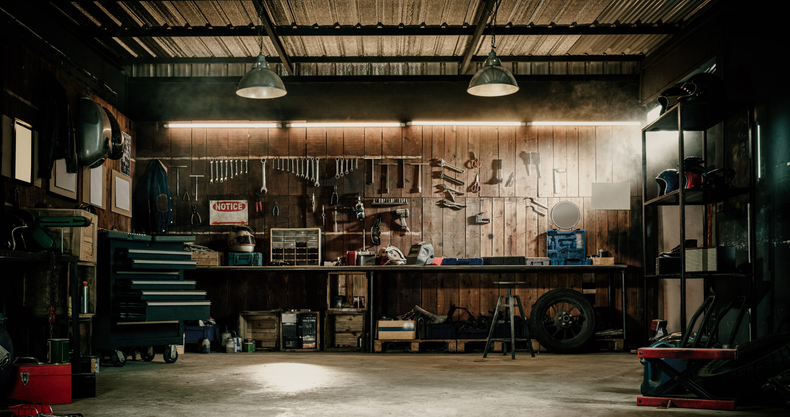 an image of the interior of aa motorcycle repair shop Workshop scene. Old tools hanging on wall in workshop, Tool shel