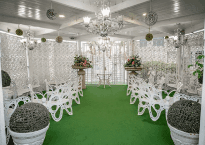 The interior of the little white wedding chapel. an altar in between two white rows of chairs.