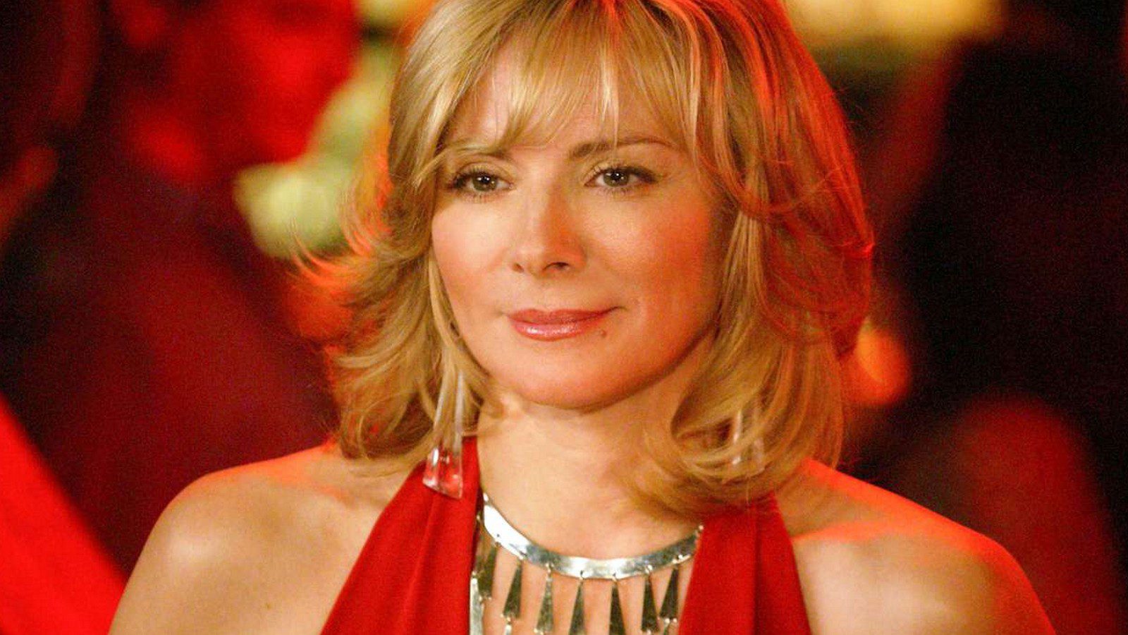 An image of a pretty middle aged blonde woman in a red halter top