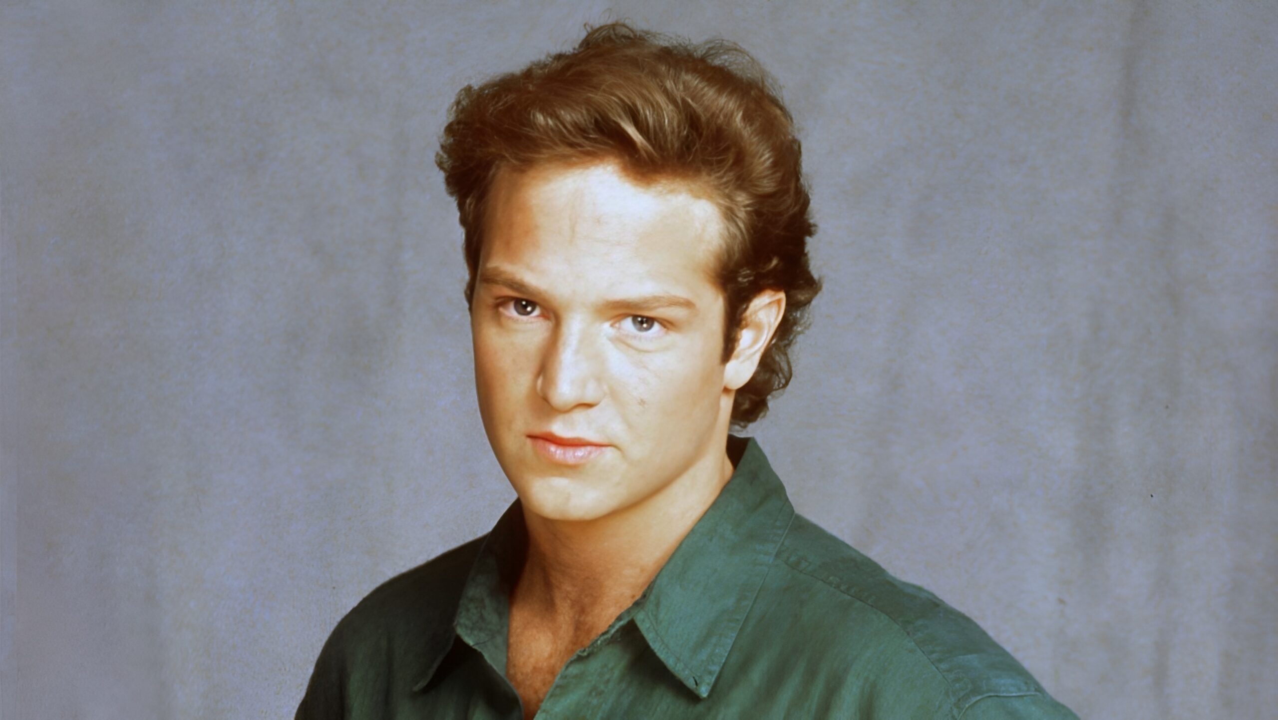 an image of a handsome man with strawberry blonde hair in a green shirt.