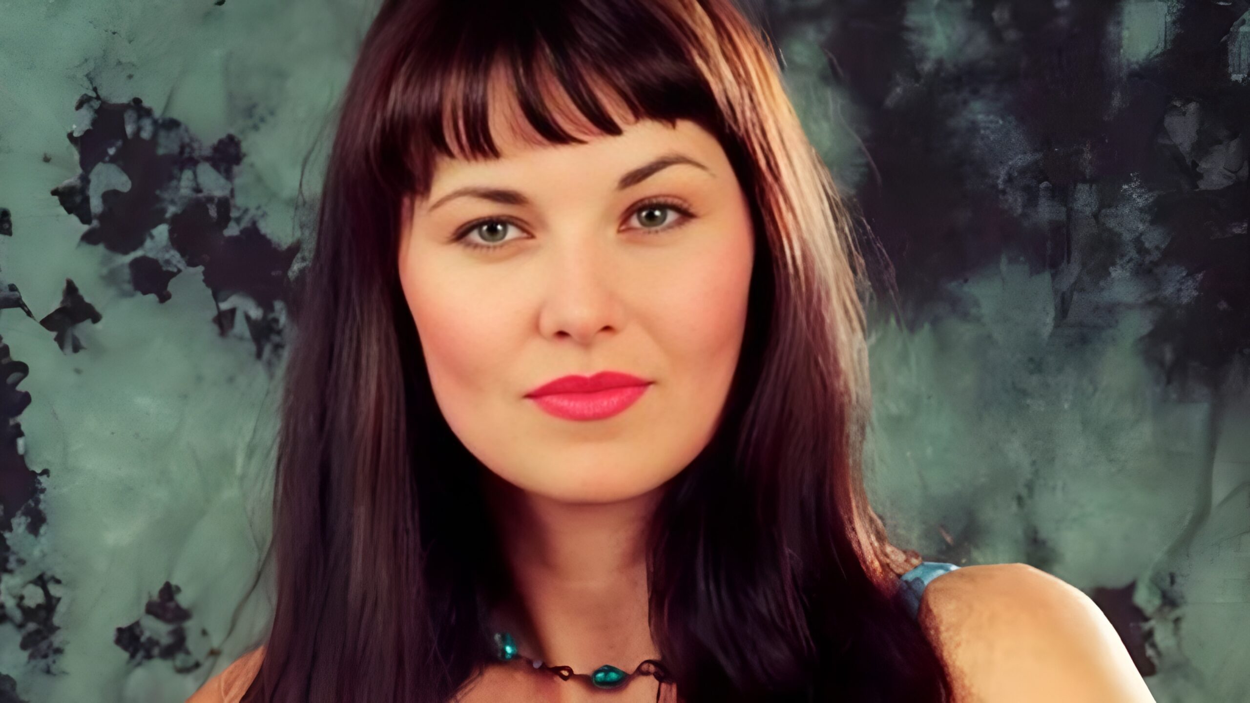 an image of a middle aged white woman with long dark hair and blue eyes. 