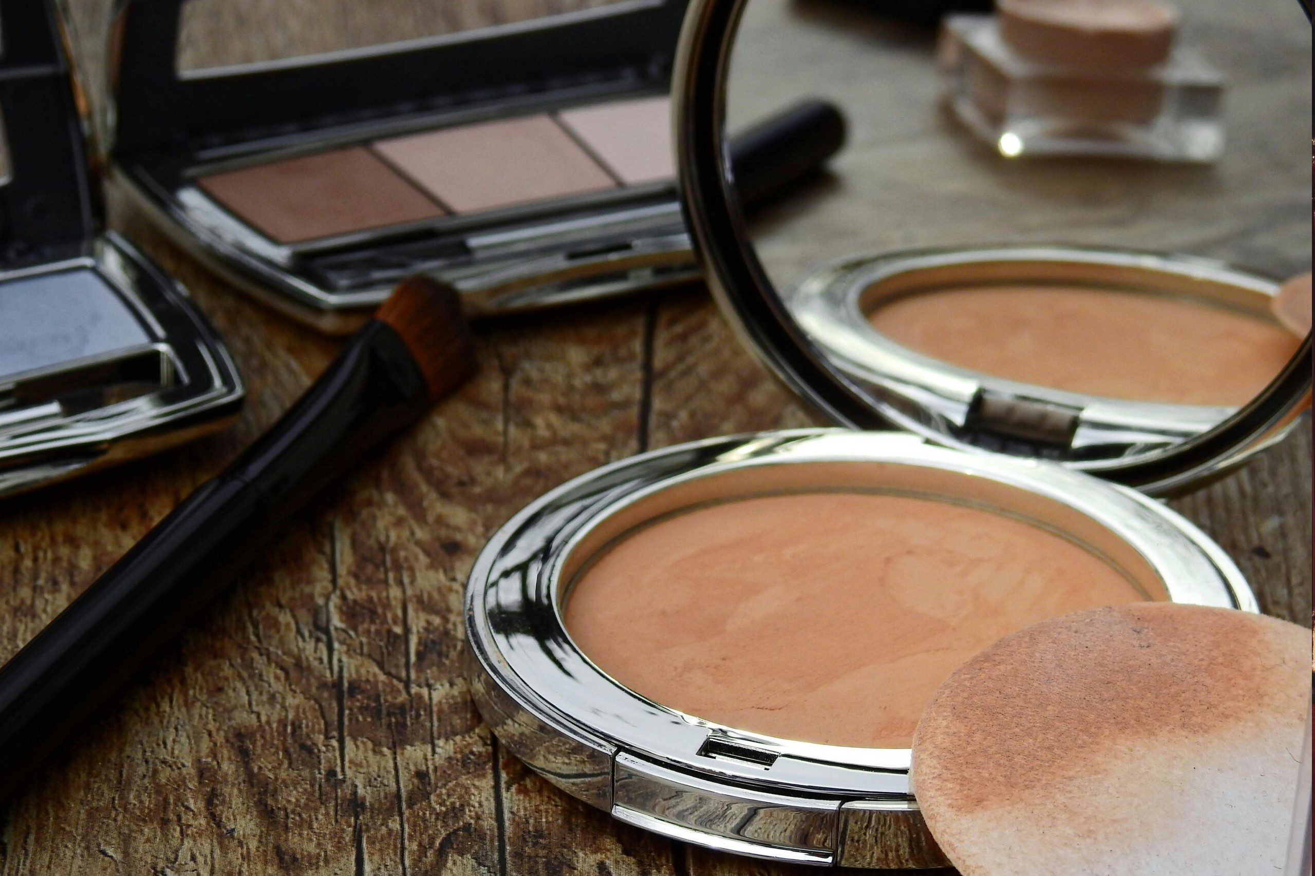 Glam Before The Storm a vanity with an open foundation, compact and eyeshadow palettes.