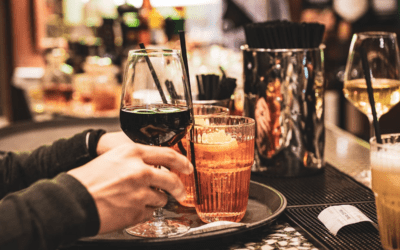 An image of a man putting up various alcoholic drinks on a tray.