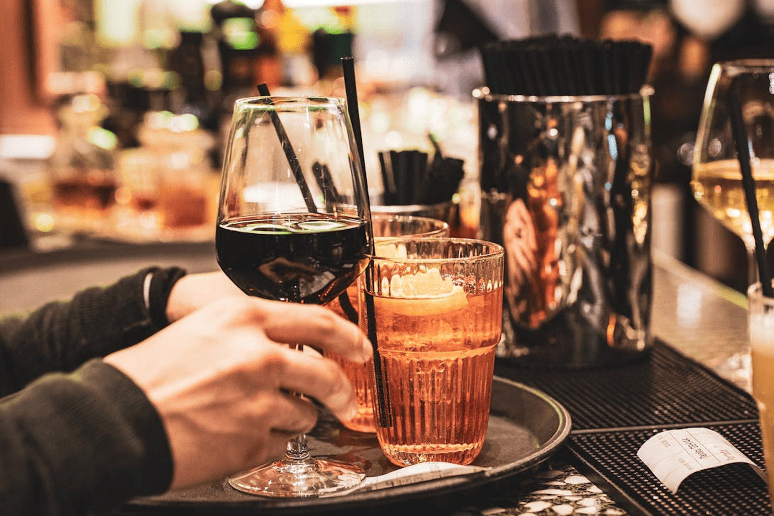 An image of a man putting up various alcoholic drinks on a tray. An image of a man putting up various alcoholic drinks on a tray.