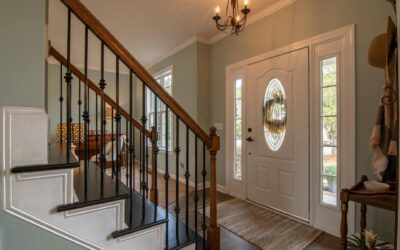 Inviting modern hallway with staircase, chandelier, and natural daylight.