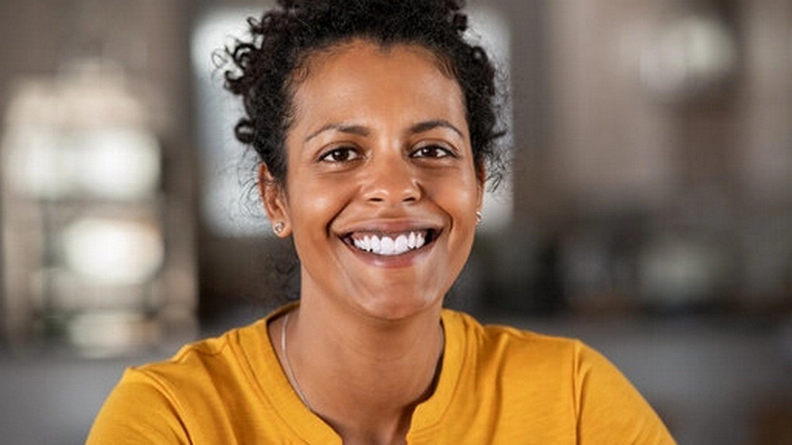 loretta coleman A smiling black woman in her mid 30s with curly hair and curly hair woman seated at a table.